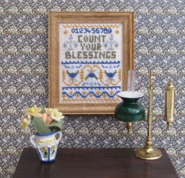 A doll's house scale 'Count Your Blessings' sampler on 32 count evenweave, available as a kit from www.janetgranger.co.uk